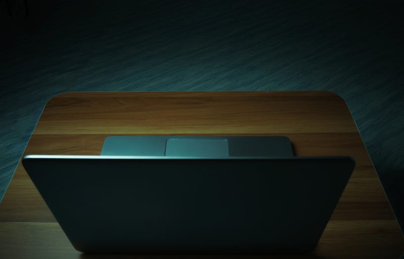 Laptop on a table in a dark room.