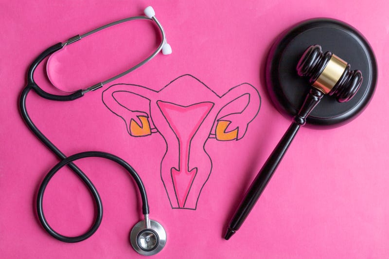 Drawing of female reproductive system with judge's gavel and stethoscope. 