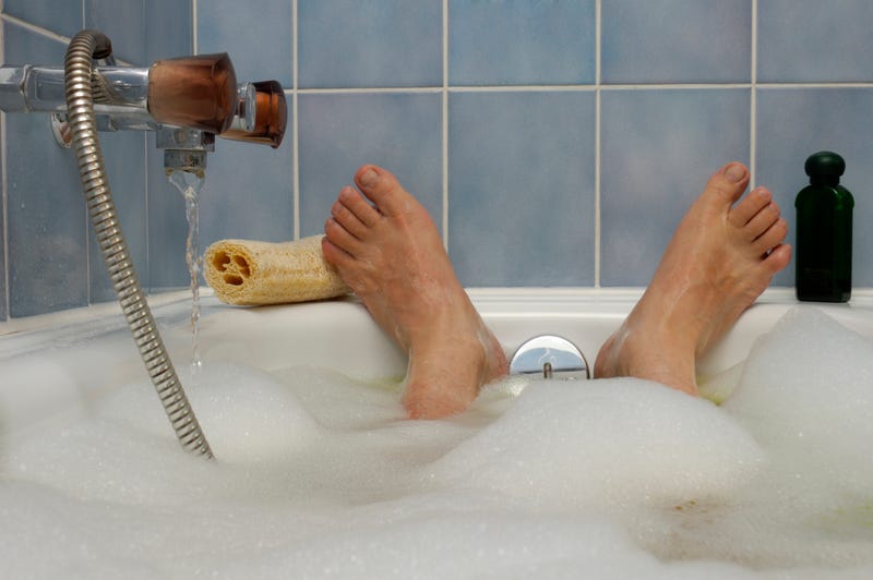 A person's feet in a bathtub. 