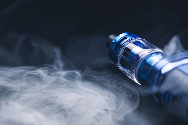 An electronic cigarette for smoking nicotine on a black background in smoke