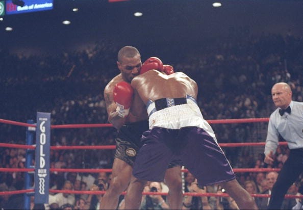 Evander Holyfield and Mike Tyson lock heads during their heavyweight title fight at the MGM Grand Garden in Las Vegas, Nevada. Holyfield won the fight when Tyson was disqualified in the third round for biting Holyfield twice. 