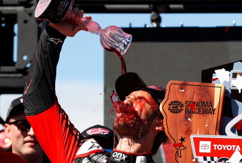 Daniel Suarez, driver of the #99 Onx Homes/Renu Chevrolet, celebrates by pouring wine on himself in victory lane after winning the NASCAR Cup Series Toyota/Save Mart 350 at Sonoma Raceway on June 12, 2022 in Sonoma, California.