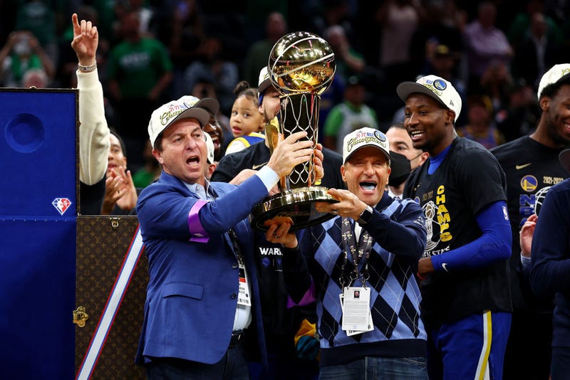 Owners Joe Lacob and Peter Guber of the Golden State Warriors raise the Larry O'Brien Championship Trophy after defeating the Boston Celtics 103-90 in Game Six of the 2022 NBA Finals at TD Garden on June 16, 2022 in Boston, Massachusetts