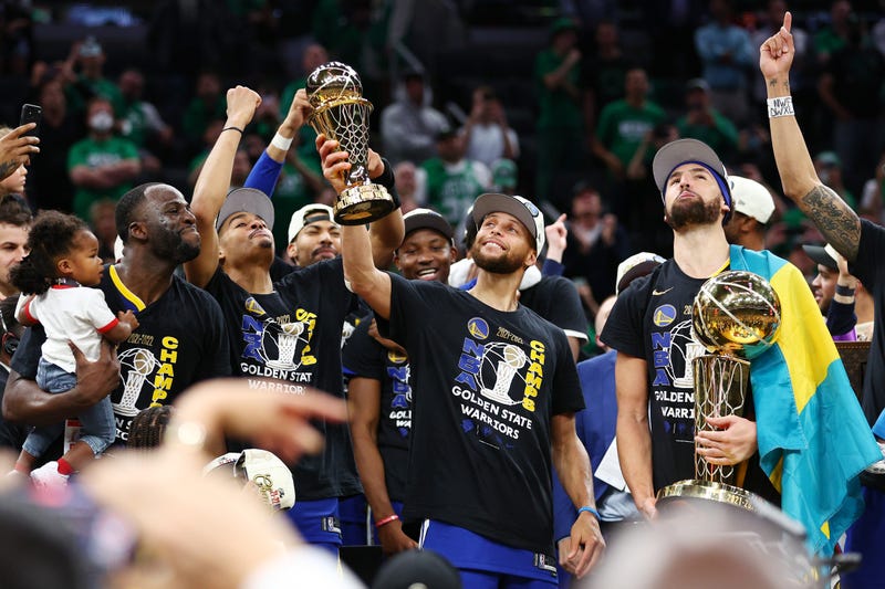 Stephen Curry #30 of the Golden State Warriors raises the Bill Russell NBA Finals Most Valuable Player Award after defeating the Boston Celtics 103-90 in Game Six of the 2022 NBA Finals at TD Garden on June 16, 2022 in Boston, Massachusetts.