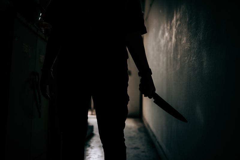 A murderer holding their weapon in the dark. 