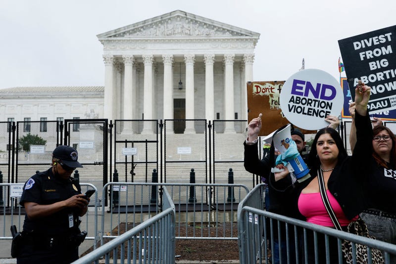 WASHINGTON, DC - JUNE 23: Anti-abortion activists protest outside the U.S. Supreme Court Building as a U.S. Capitol Police Officer stands by on June 23, 2022 in Washington, DC. The court announced a highly-anticipated ruling on gun rights from New York, but activists continue to wait on the potential overturning of Roe vs Wade.