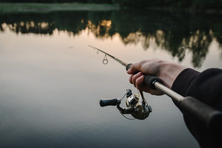 Fisherman with rod, spinning reel on a boat
