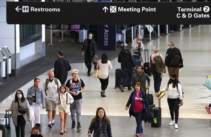 Travelers walk with their luggage at San Francisco International Airport on July 01, 2022 in San Francisco, California.