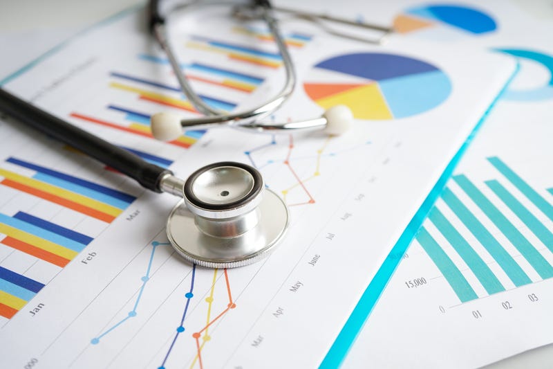 stethoscope on papers with charts and graphs