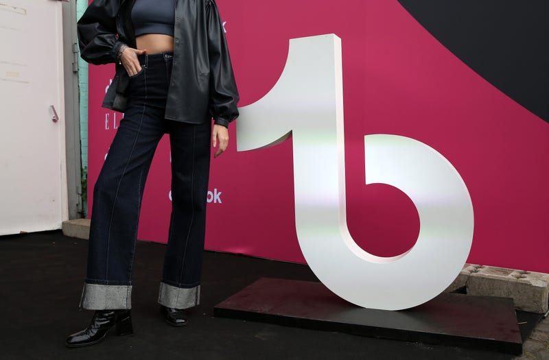 BERLIN, GERMANY - JULY 06: A visitor poses with the logo of the short-form video hosting service TikTok at an event called "The Future of Fashion" on July 06, 2022 in Berlin, Germany. The theme of the evening was "How Will You Dress 10 Years From Now?"