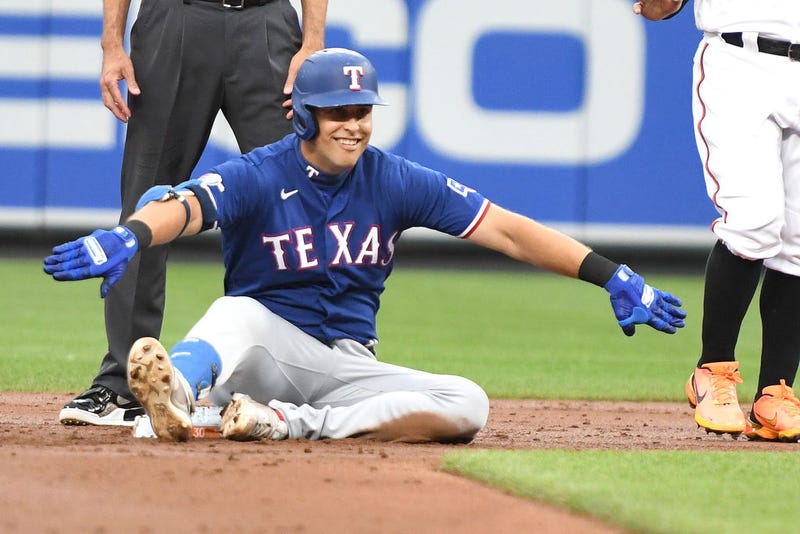 Nathaniel Lowe #30 of the Texas Rangers slides into second safely for a double in the second inning during a baseball game against the Baltimore Orioles at Oriole Park at Camden Yards on July 6, 2022 in Baltimore, Maryland.
