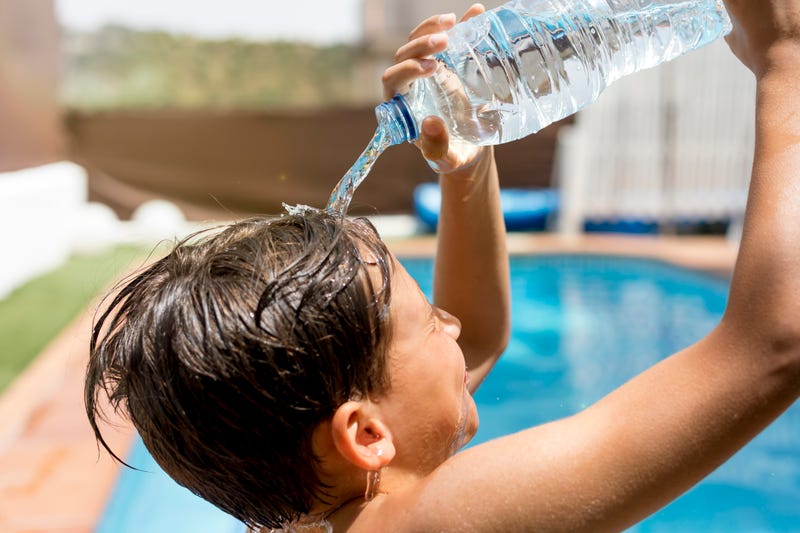 Kid cooling of by pouring water on his head