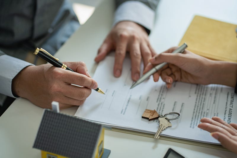 Person signing papers in purchasing a house