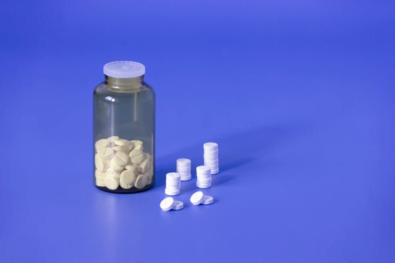 Pills in a bottle and on the counter.