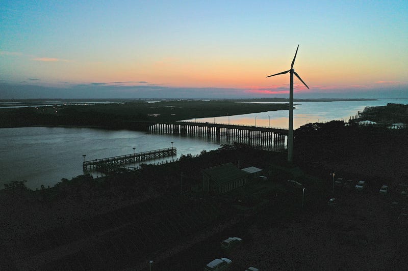 A wind turbine spins at sunrise on July 20, 2022 in Lido Beach, New York.