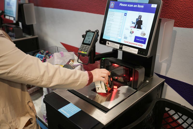 TARLETON, UNITED KINGDOM - JULY 22: A customer uses a self checkout terminal at the new Tarleton Aldi store on July 22, 2022 in Tarleton, United Kingdom. Aldi is the UK’s fifth largest supermarket chain and has 950 stores. The new Aldi store is the first in the Preston area.