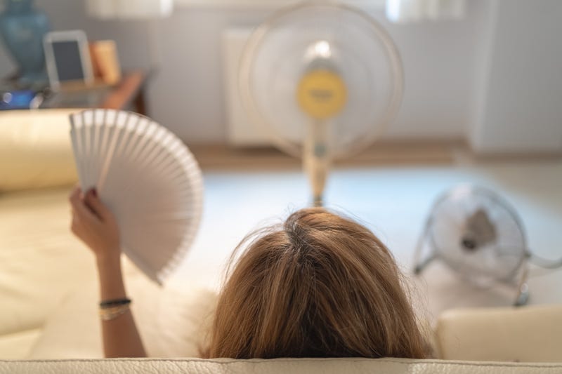 Woman trying to cool down in the heat. 