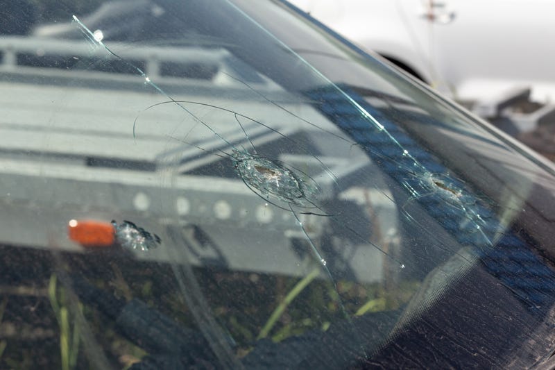 Bullet holes in the windshield of a car stock photo.