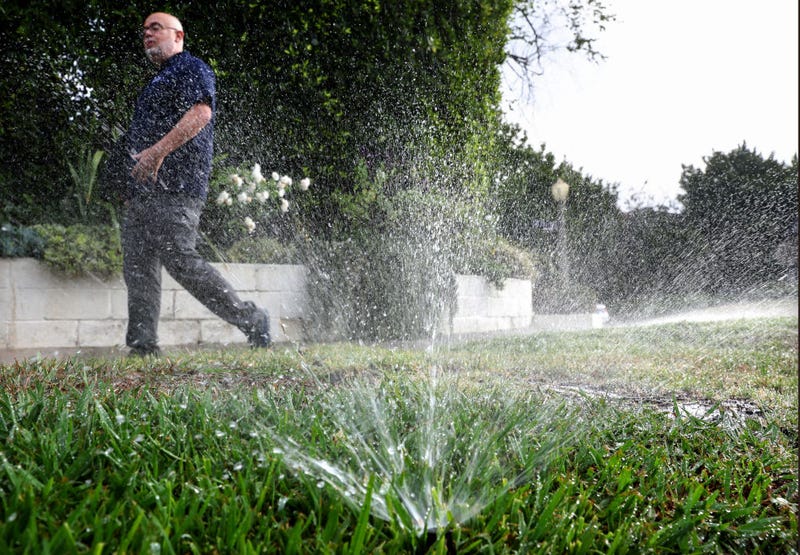 Los Angeles Department of Water and Power (LADWP) water conservation specialist Damon Ayala walks while inspecting a sprinkler system, which is operating in violation of the water conservation ordinance, on July 27, 2022 in Los Angeles, California.