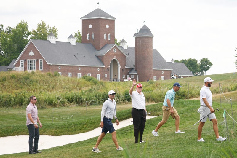 Former U.S. President Donald Trump talks to Bryson DeChambeau of Crushers GC and Dustin Johnson of 4 Aces GC walk from the 14th green to the 15th tee during the pro-am prior to the LIV Golf Invitational - Bedminster at Trump National Golf Club Bedminster on July 28, 2022 in Bedminster, New Jersey.