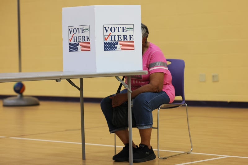 person votes at a st. louis county voting booth