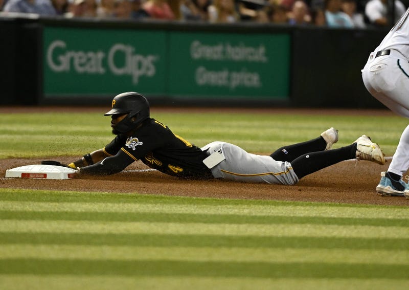 Rodolfo Castro, #14 of the Pittsburgh Pirates, slides into third base as his cell phone falls out of his pocket during the fourth inning of a game against the Arizona Diamondbacks at Chase Field on Aug. 9, 2022, in Phoenix, Arizona.