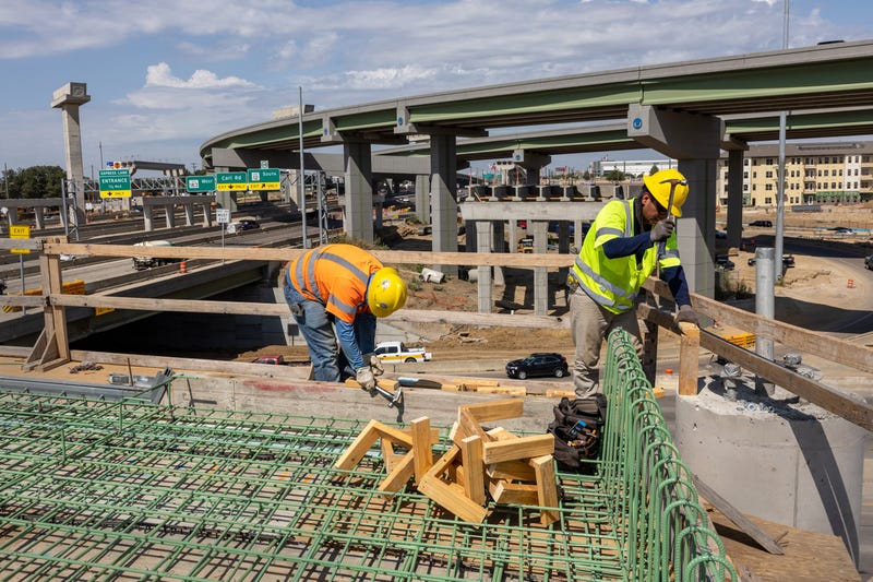 FILE: Workers construct an overpass as part of the Irving Interchange infrastructure project near the site of the former Dallas Cowboys Stadium on Aug. 10, 2022, in Irving, Texas.