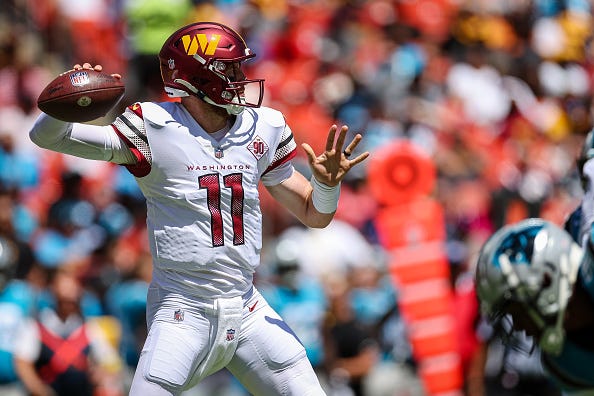 Carson Wentz models the Commanders white uniforms. 
