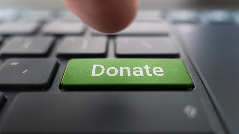 green donate button on the keyboard close-up. blurred in motion background