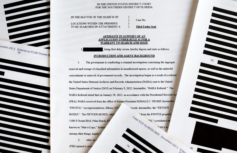 In this photo illustration, pages are viewed from the government’s released version of the F.B.I. search warrant affidavit for former President Donald Trump's Mar-a-Lago estate on August 27, 2022 in California. The 32-page affidavit was heavily redacted for the protection of witnesses and law enforcement and to ensure the ‘integrity of the ongoing investigation’. (Photo Illustration by Mario Tama/Getty Images)