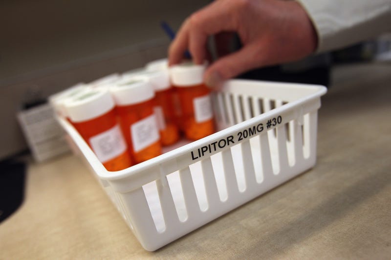 AURORA, CO - MARCH 27: Pharmacy director Hank Wedemeyer takes a bottle of cholesterol-reduction medication while filling prescriptions at a community health center on March 27, 2012 in Aurora, Colorado.