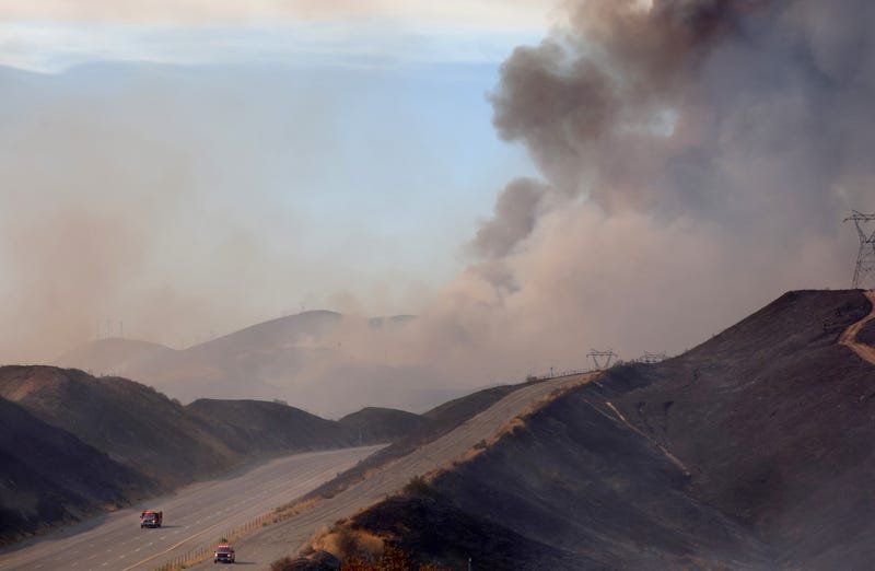 A firefighting helicopter drops water near a hotspot along a reopened section of the 5 freeway which was closed yesterday as the Route Fire burned on September 1, 2022 near Castaic, California.