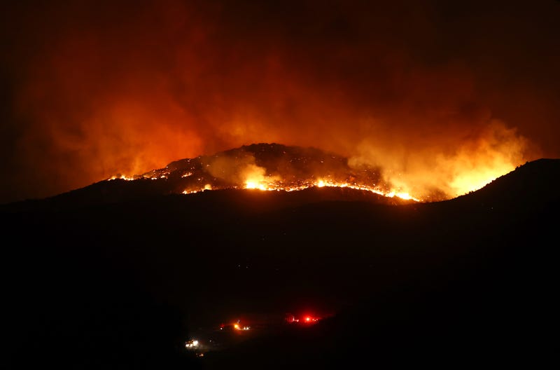 The Fairview Fire burns above lights from first responder vehicles on September 5, 2022 near Hemet, California.