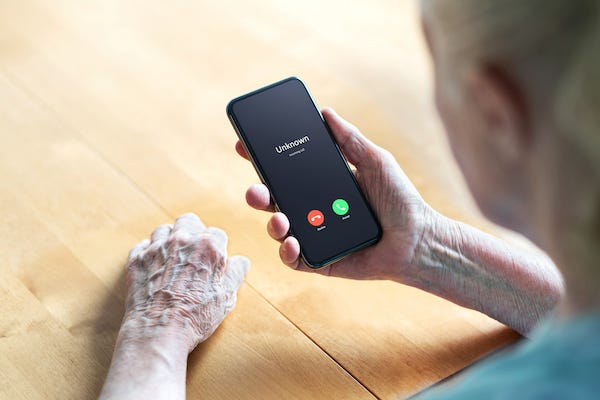 Elderly man receiving a phone call from an unknown number