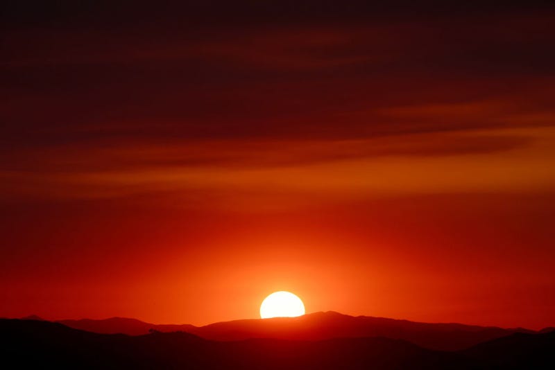 The sun sets through the haze of wildfire smoke as the Fairview Fire burns on September 6, 2022 near Hemet, California.
