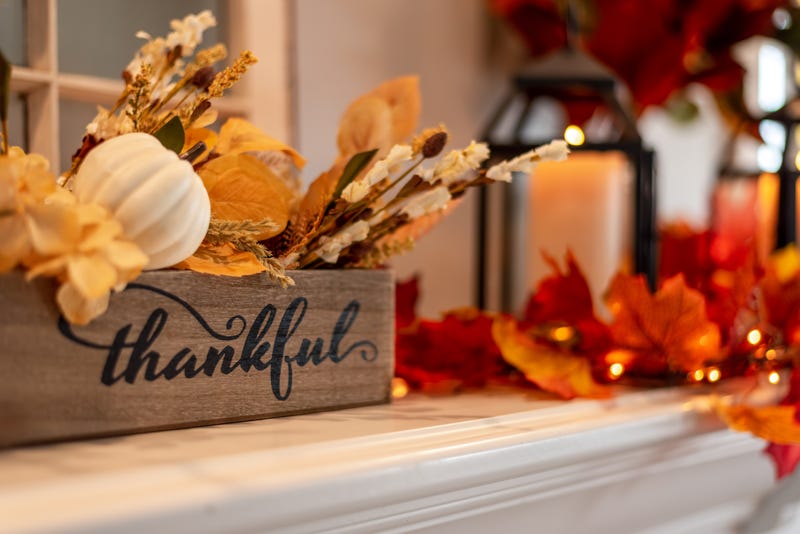 Mantel decorated for fall with autumn leaves and twinkling lights
