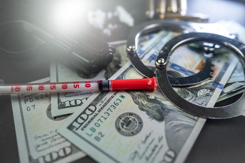 Drugs, money, gun with silencer and handcuffs isolated on black table.