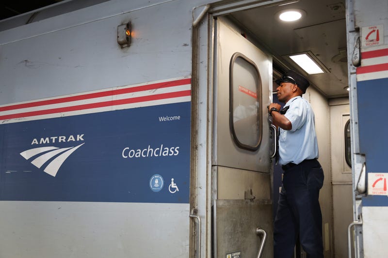 Amtrak conductor Eric Courtney makes announcements to passengers as they board a train.