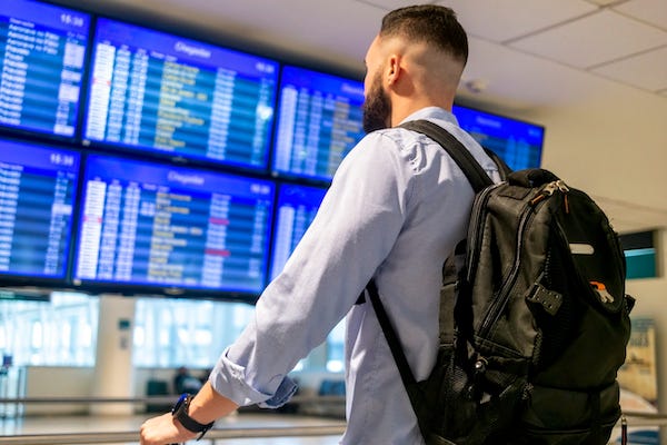  Man looking at screen of flights at an airport