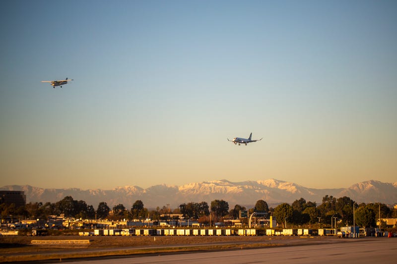 two planes landing at airport at dusk