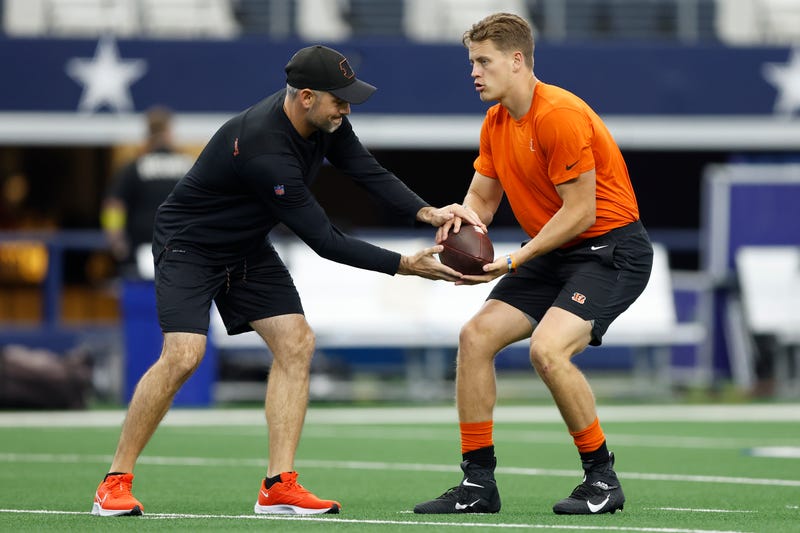 ARLINGTON, TEXAS - SEPTEMBER 18: Joe Burrow #9 of the Cincinnati Bengals runs warmup drills with quarterbacks coach Dan Pitcher before the game against the Dallas Cowboys at AT&T Stadium on September 18, 2022 in Arlington, Texas. 