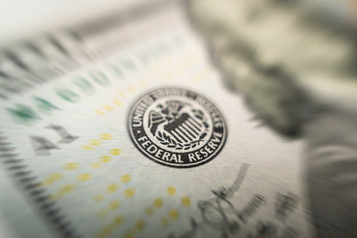 Selective focus on US Federal Reserve emblem on hundred dollars banknote as FED consider interest rate hike, economics and inflation control national organization