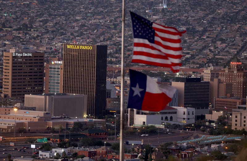 An American and Texas flag are seen flying in front of the skyline of El Paso and Ciudad Juarez on September 23, 2022 in El Paso, Texas