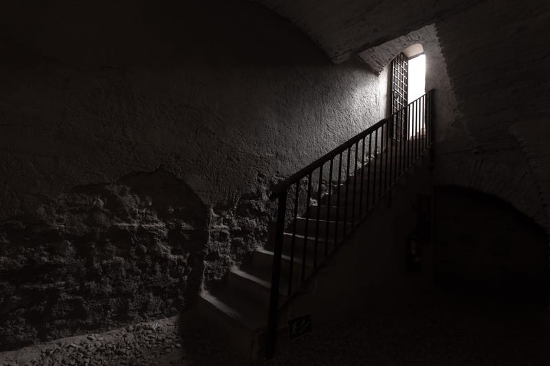 Old wrought iron stairs and light at the end of a tunnel