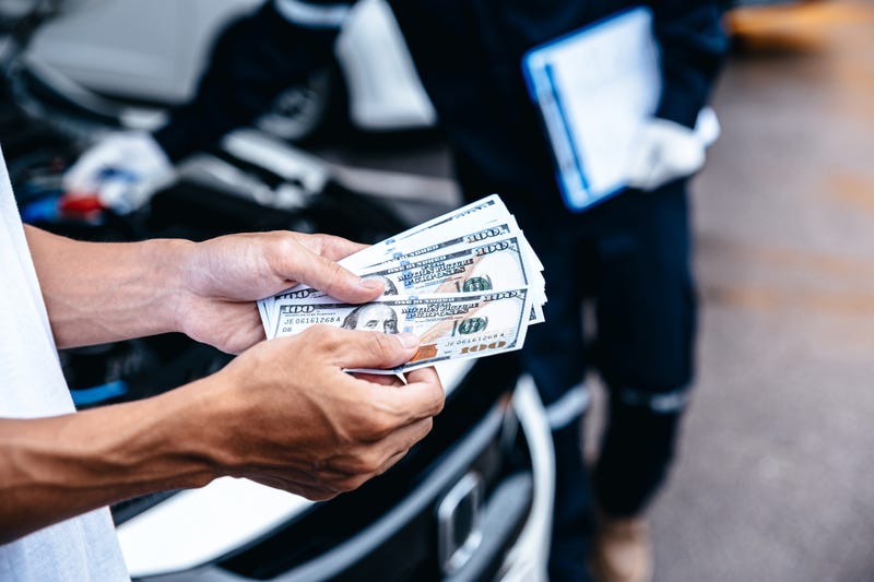 Customer pay with money for repair to the mechanic at garage workshop, Spending and car financial concept.