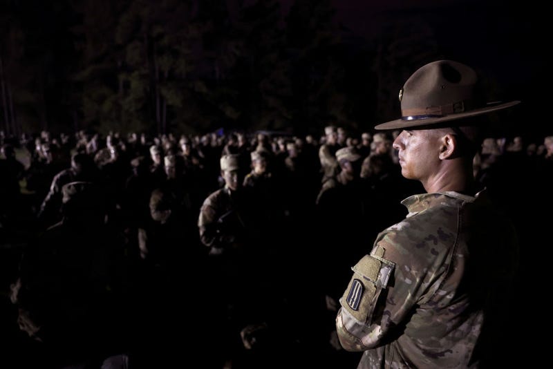 U.S. Army trainees assemble in the pre-dawn hours following a grueling 81-hour field training exercise known as the Forge and before the start of their Soldier's Ceremony on September 29, 2022 in Columbia, South Carolina. During the ceremony the trainees don their black beret, affix their Army patch and rank to their uniform and begin to be referred to as soldiers rather than trainees. Fort Jackson, the largest of the Army's four basic training facilities, trains 60 percent of the Army's new recruits. This past year, the Army has struggled to meet its recruiting goals, falling short by about 15,000 recruits or about 25 percent of its goal as it closed the fiscal year. (Photo by Scott Olson/Getty Images)