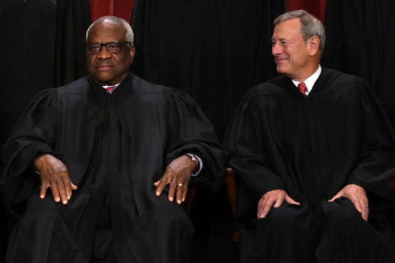  United States Supreme Court Associate Justice Clarence Thomas (L) and Chief Justice of the United States John Roberts (R) pose for their official portrait at the East Conference Room of the Supreme Court building on October 7, 2022 in Washington, DC. The Supreme Court has begun a new term after Associate Justice Ketanji Brown Jackson was officially added to the bench in September. (Photo by Alex Wong/Getty Images)