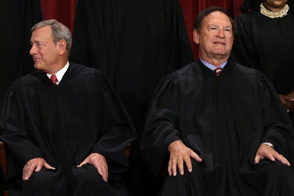 United States Supreme Court Chief Justice John Roberts (L) and Associate Justice Samuel Alito (R) pose for an official portrait at the East Conference Room of the Supreme Court building on October 7, 2022 in Washington, DC. 