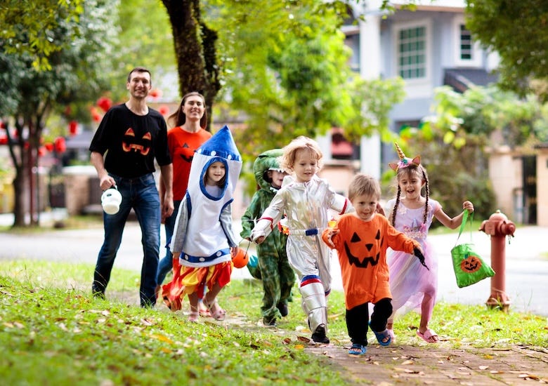 A family trick-or-treating in a neighborhood