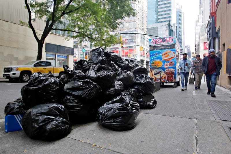 People make their way past trash bags in New York